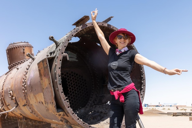 Turista allegra vicino a un cimitero ferroviario a Uyuna, in Bolivia