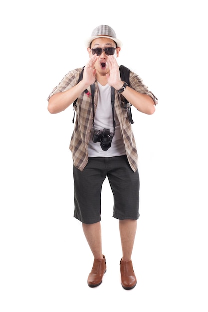 Turista asiatico con cappello, occhiali da sole, telecamera e zaino a spalla che urla un annuncio.