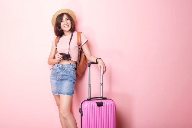 Turista asiatico felice della donna sulla parete rosa