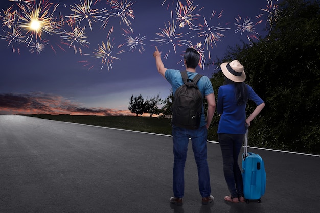 Turista asiatico felice delle coppie che guarda i bei fuochi d&#39;artificio