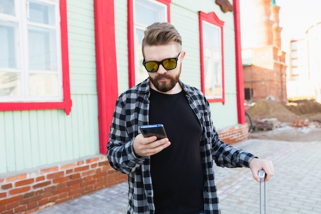 Turista barbuto perso in città e utilizza la mappa online dello smartphone per trovare le giuste indicazioni. Concetto di viaggio e viaggio.