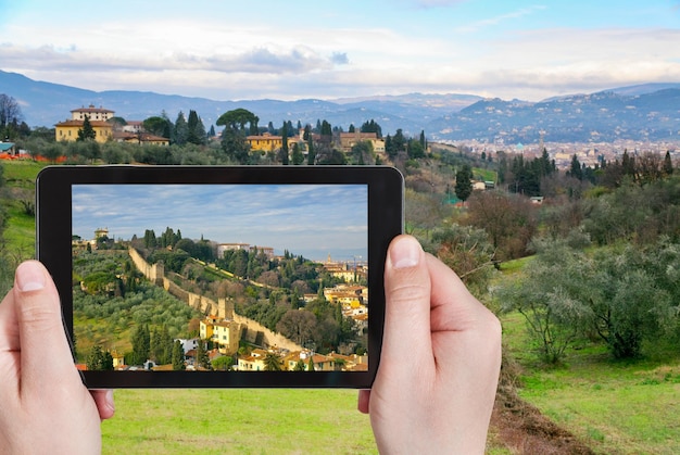 Turista che cattura foto delle verdi colline toscane