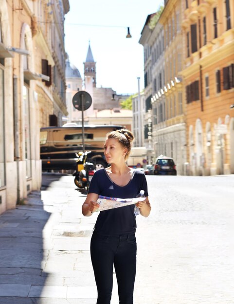 Turista che guarda la mappa donna che cammina in città