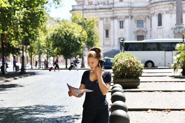 Turista che guarda la mappa donna che cammina in città