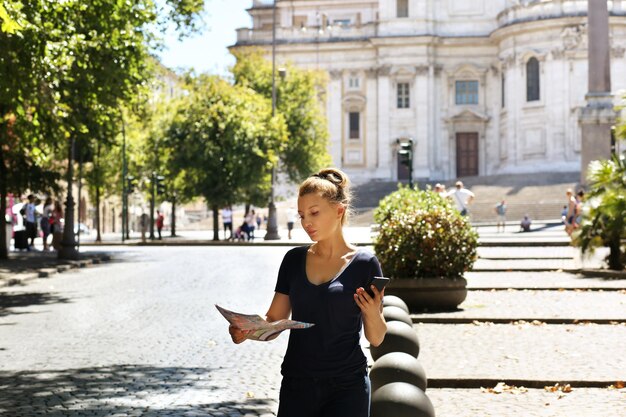 Turista che guarda la mappa donna che cammina in città