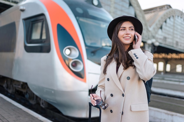 Turista che parla al telefono vicino al treno