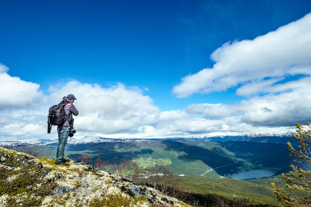 Turista del fotografo naturalista con riprese della fotocamera mentre si trova in cima alla montagna. Bella natura Norvegia.