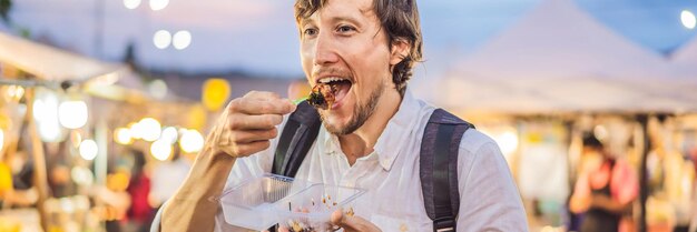 Turista del giovane sul formato lungo dell'insegna del mercato alimentare asiatico della via pedonale