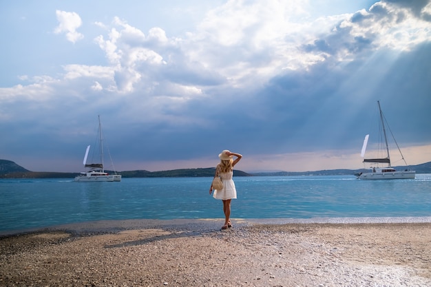 Turista della bella ragazza che cammina al porto marittimo grecia del porticciolo di ermioni