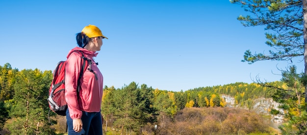 Turista della donna che esamina la foresta di autunno