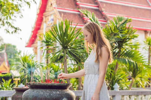 Turista della donna nei precedenti del tempio tailandese Wat Chalong.