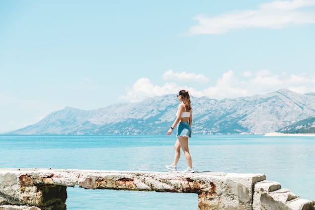 Turista della donna nella splendida posizione in viaggio dopo il blocco sentirsi libero godendo della vista della montagna del mare e dell'aria fresca