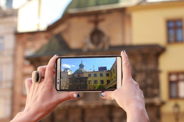 Turista della donna scatta foto sullo smartphone in strada