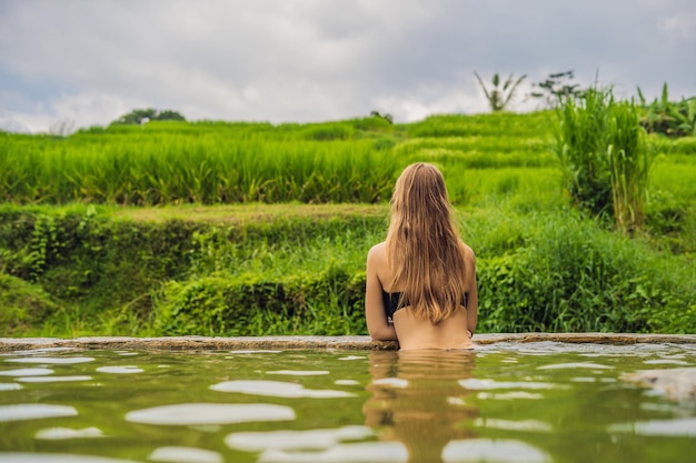 Turista della giovane donna a Belulang Hot Springs a Bali sullo sfondo delle terrazze di riso.