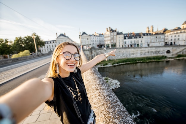 Turista della giovane donna che fa la foto del selfie sul bello sfondo di paesaggio urbano a Orleans, France