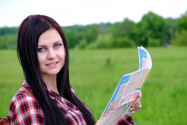 Turista della giovane donna con zaino e mappa sullo sfondo del bellissimo paesaggio