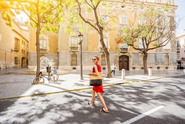 Turista della giovane donna in vestito rosso che cammina la via nella vecchia città della città di Valencia, Spain