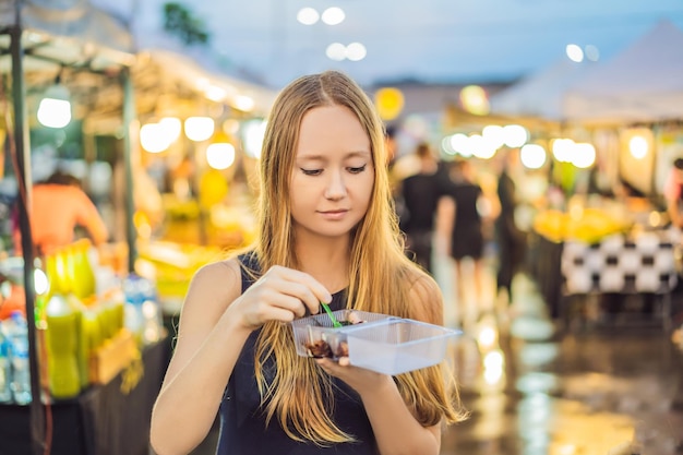 Turista della giovane donna sul mercato alimentare asiatico di Walking Street