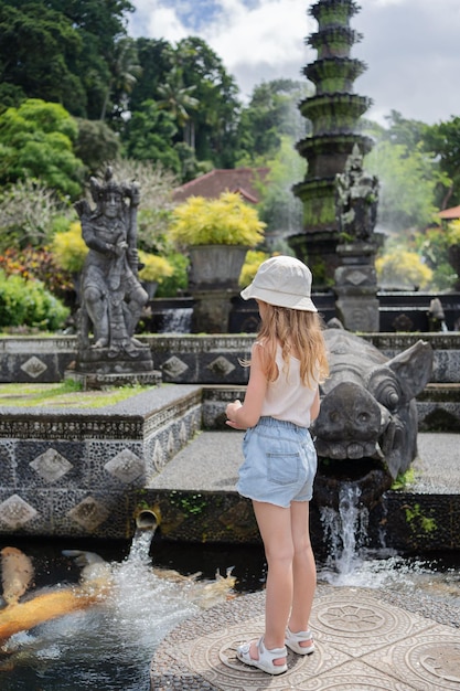 Turista della ragazza del bambino nel parco acquatico del palazzo dell'acqua di taman tirtagangga bali indonesia che viaggia con il bambino