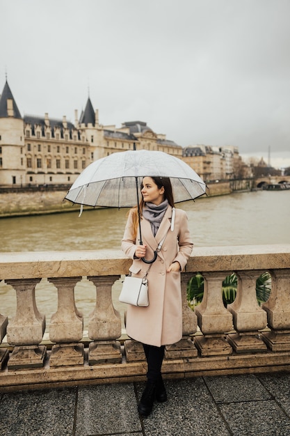 Turista della ragazza elegante in piedi su un ponte sulla Senna a Parigi.