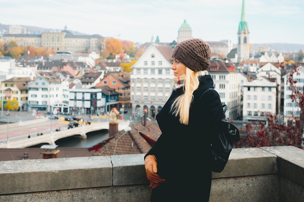 Turista della ragazza in vestiti caldi che esplorano la nuova città all'autunno