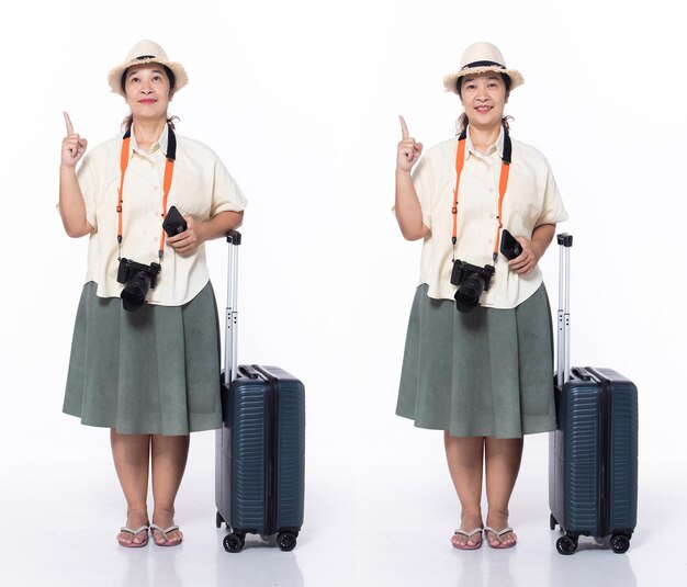 Turista di vacanza della donna anziana asiatica degli anni '50 a tutta lunghezza che punta il dito verso l'alto in aria