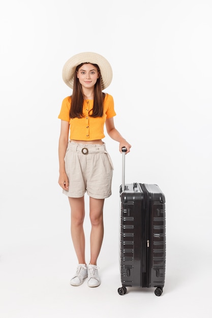 Turista donna. Giovane donna felice integrale che sta con la valigia con gesturing emozionante, isolato.