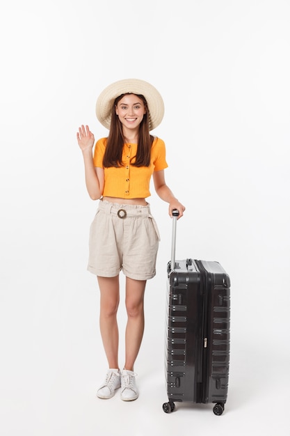 Turista donna. Giovane donna felice integrale che sta con la valigia con gesturing emozionante, isolato.