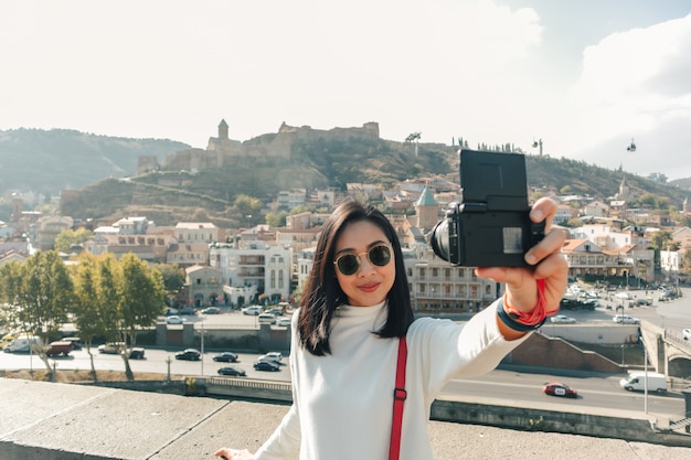 Turista donna sta prendendo selfie di se stessa e la vista della città vecchia di Tbilisi in Georgia.