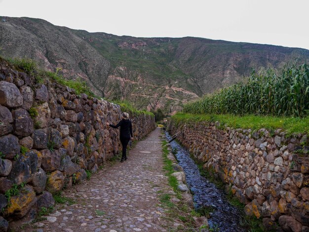 turista Donna sulle piattaforme giganti di Yucay nella Valle Sacra degli Incas Cusco