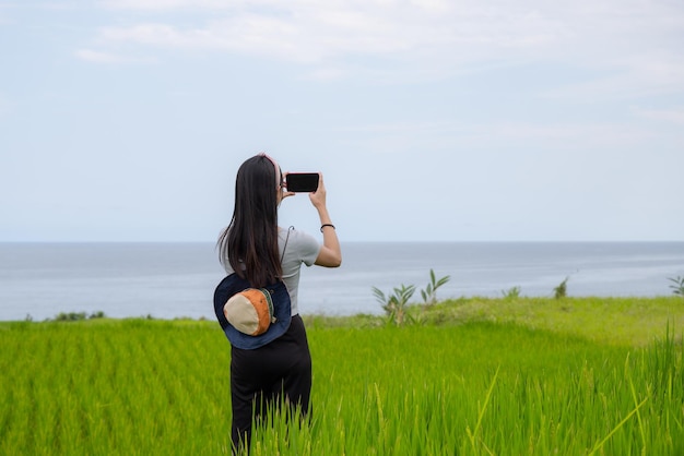 Turista donna usa il cellulare per scattare foto in campagna