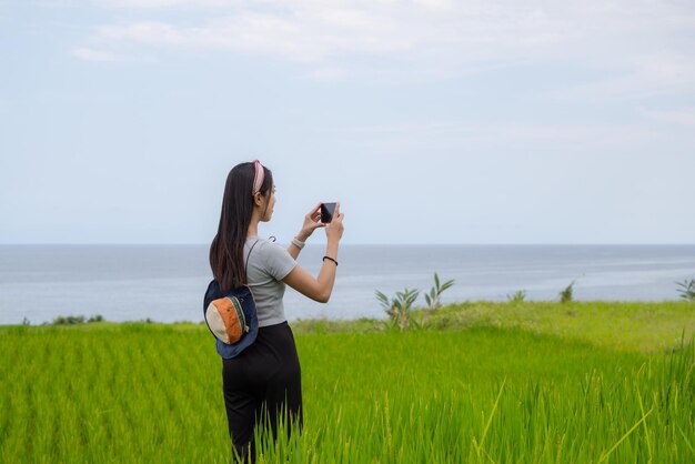 Turista donna usa il cellulare per scattare foto in campagna