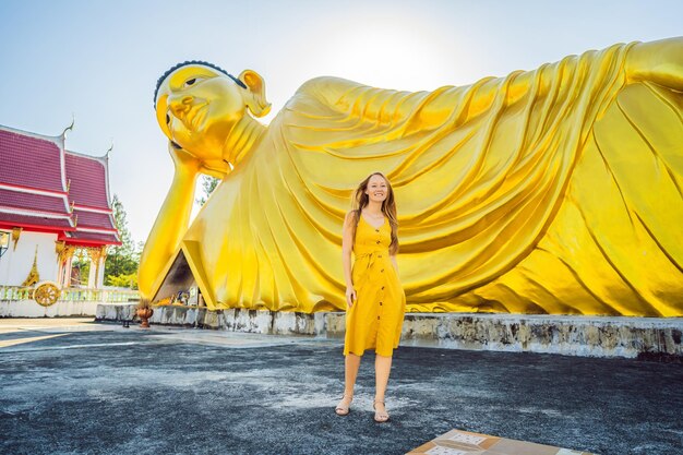 Turista felice della donna sullo sfondo della statua del Buddha sdraiato