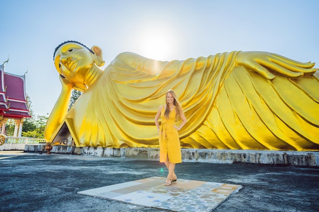 Turista felice della donna sullo sfondo della statua del Buddha sdraiato