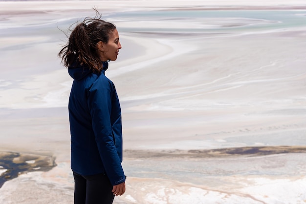 Turista femminile che gode del vento sulla giornata di sole nell'arido deserto di Atacama in Cile