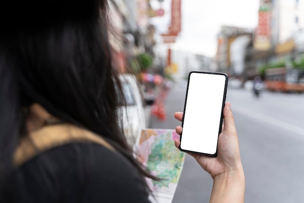 Turista femminile che mostra lo schermo mobile moderno dello smartphone in Chinatown Bangkok Tailandia