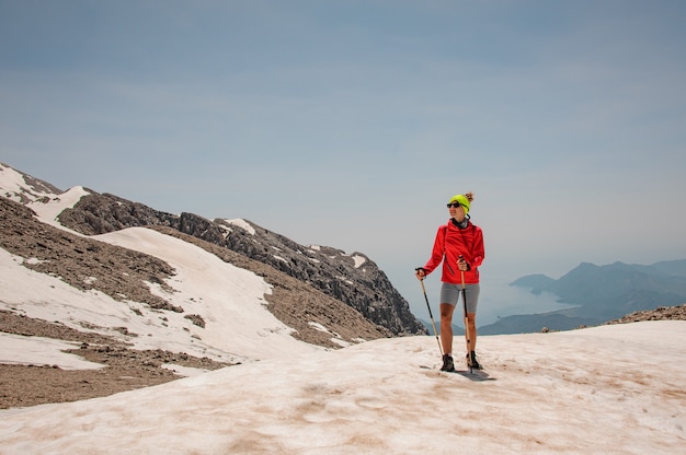 Turista femminile con i bastoni da passeggio in montagne