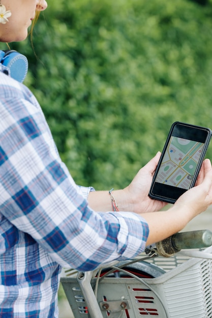 Turista femminile in bicicletta utilizzando la mappa GPS