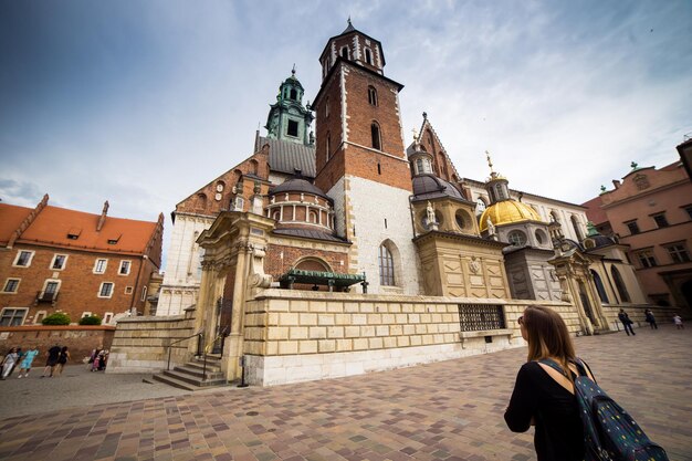 Turista giovane e felice che cammina sul castello di Wawel nella vecchia città europea Cracovia Polonia Viaggia in giro per l'Europa