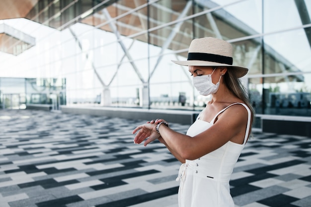 Turista in maschera madical in attesa di un volo vicino all'aeroporto