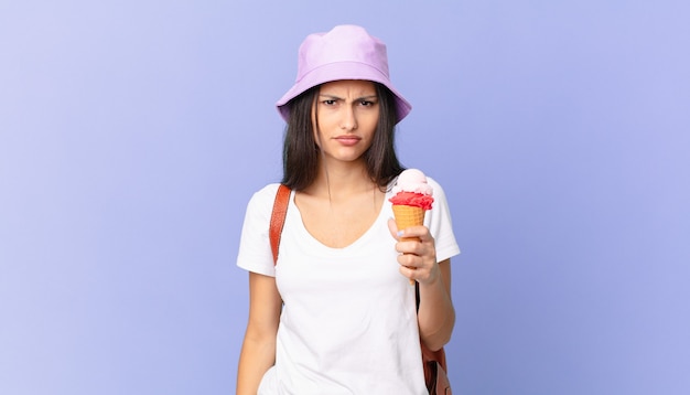 Turista piuttosto ispanico che si sente perplesso e confuso e tiene in mano un gelato