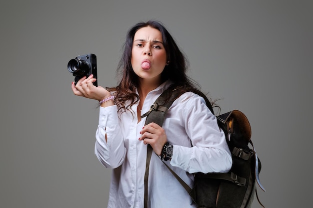 Turista positiva con macchina fotografica e zaino da viaggio.