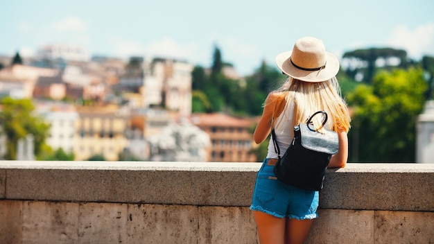 Turista sorridente attraente della giovane ragazza che esplora la nuova città in estate