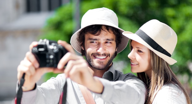 Turista sorridente che mostra le foto alla sua ragazza