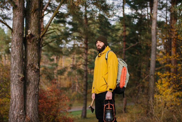 Turista su un sentiero nella foresta con uno zaino e una lampada