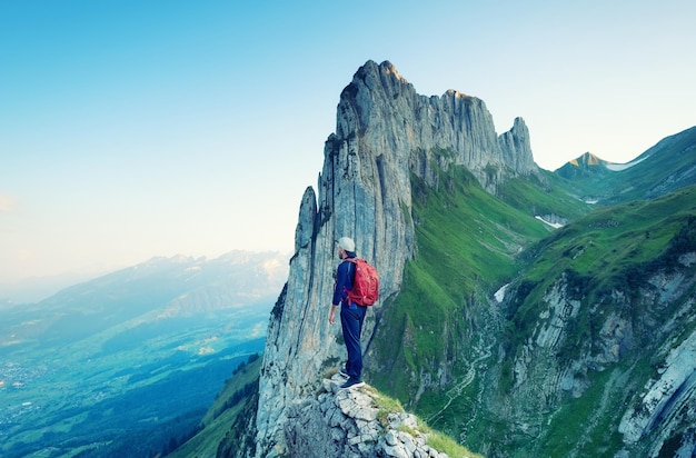 Turista sullo sfondo di rocce alte Sport e concetto di vita attiva Avventura e viaggi nella regione montuosa delle montagne svizzere