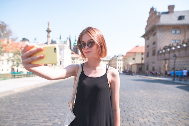 Turista sullo sfondo prende selfie strade della città vecchia