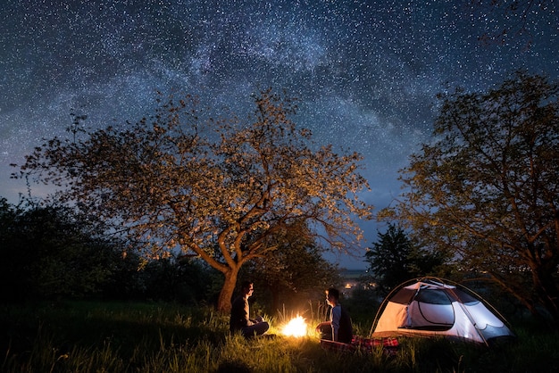 Turisti al fuoco vicino alla tenda di notte