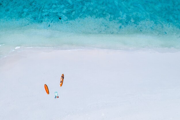 Turisti arancio di kayak di colore pastello sulla spiaggia di sabbia