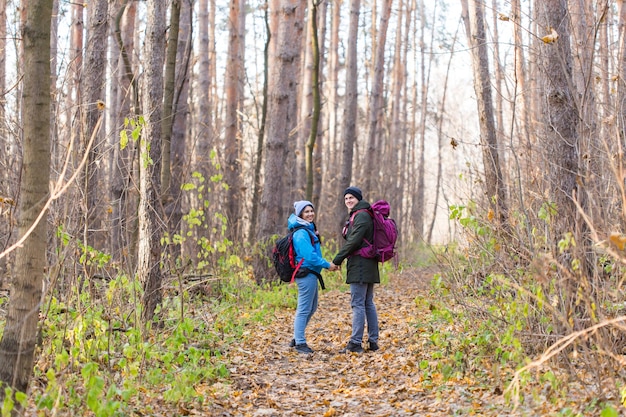 Turisti che camminano nel parco con lo zaino vestiti di blu